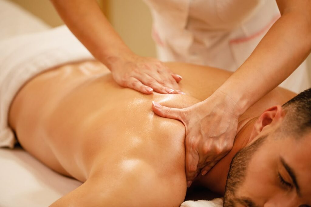 close up of man having back massage during spa treatment at wellness center.